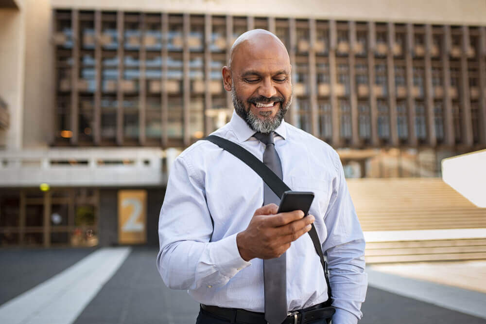 Middle-aged man in tie looking at phone
