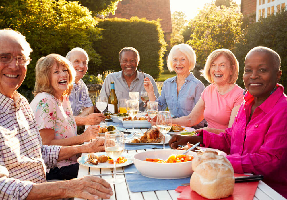 Group of mature adults having a meal together outside